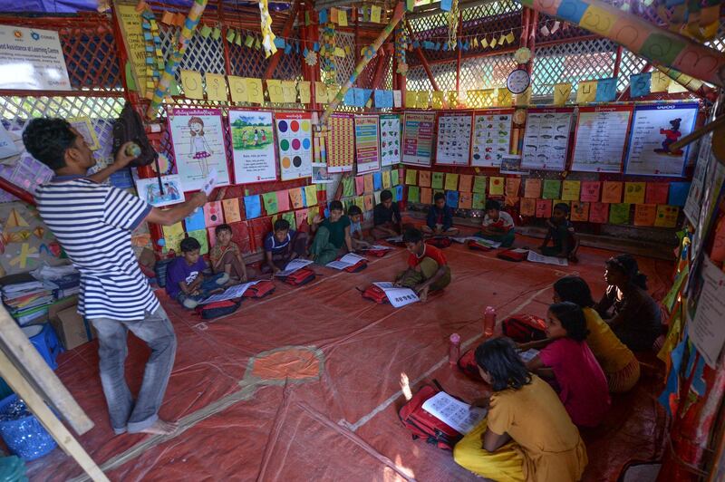 Rohingya children attend a lesson to learn their language at a school at Jamtola refugee camp in Ukhia on December 9, 2019. (Photo by MUNIR UZ ZAMAN / AFP)