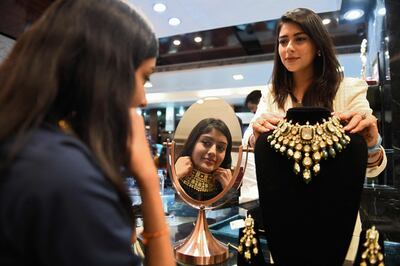A woman tries a necklace on the occasion of Dhanteras ahead of the Hindu festival of Diwali at a jewellery store in Amritsar. AFP