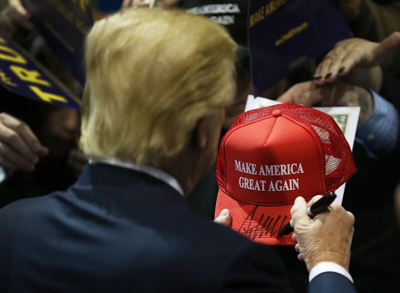 Republican presidential candidate Donald Trump signs one of his campaign hats during an event in Iowa this winter. Joe Raedle / Getty Images