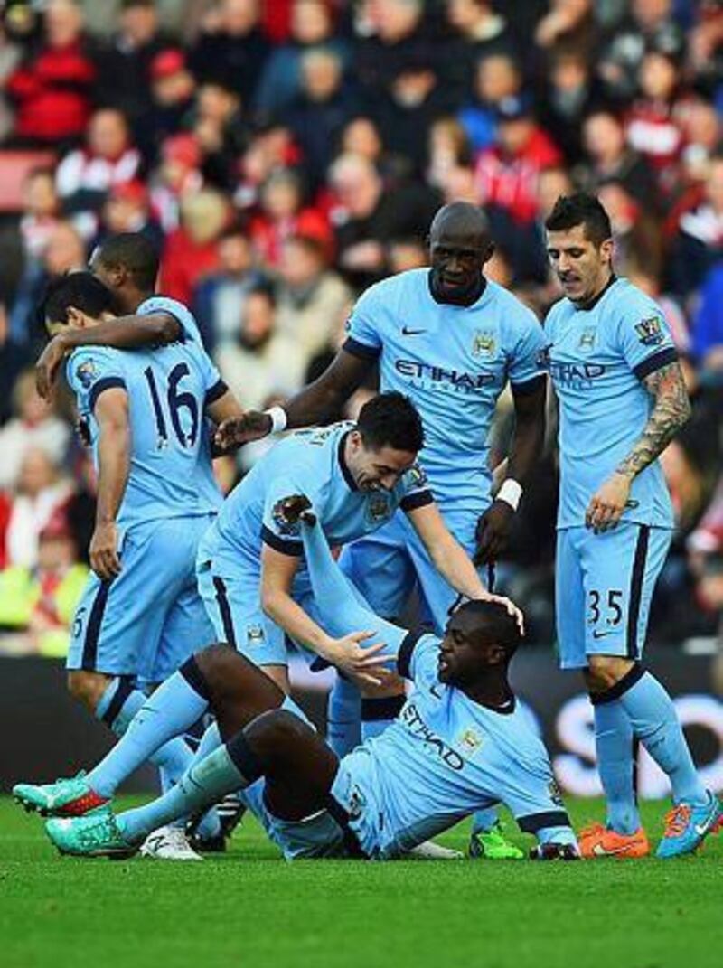 Yaya Toure of Manchester City (grounded) celebrates with teammates as he scores their first goal during their Premier League match against Southampton at St Mary's Stadium on November 30, 2014 in Southampton, England. (Photo by Shaun Botterill/Getty Images)