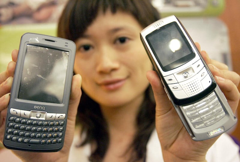 A Chinese promotion girl shows off the latest mobile phones from Taiwan's BenQ, at a launch in Beijing, 08 June 2005.  Taiwan's BenQ Corp said it aims to secure 10 percent of China's cellphone handset market in three years after the company won a permit to sell its products on its own on the mainland, as previously, BenQ relied on its joint venture with China-based CEC Telecom Co for sales of its handsets under a dual-brand strategy on the mainland.         AFP PHOTO (Photo by STR / AFP)