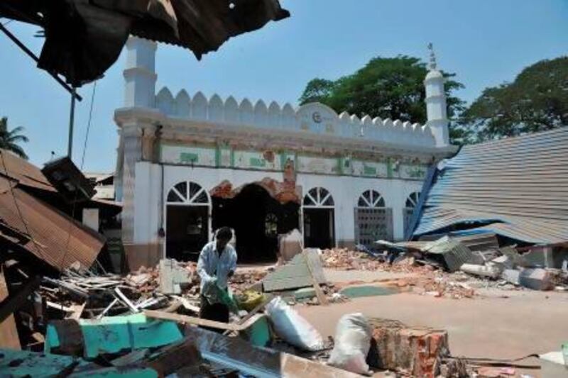 A man salvages items in the courtyard of a partially-destroyed mosque after sectarian violence spread through central Myanmar, in Gyobingauk.