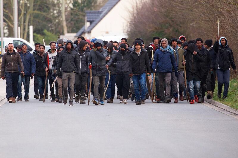 epa06490611 A group of migrants carrying sticks during clashes near the ferry port in Calais, northern France, 01 February 2018. Four migrants have been shot and seriously inrured in Calais in a confrontation that police tried to stop, French authorities confirmed. About 100 migrants fought with stones and sticks after a meal distribution, according to the prefecture of Pas-de-Calais.  EPA/JOHAN BEN AZZOUZ FRANCE OUT - SHUTTERSTOCK OUT - NO MAGAZINES