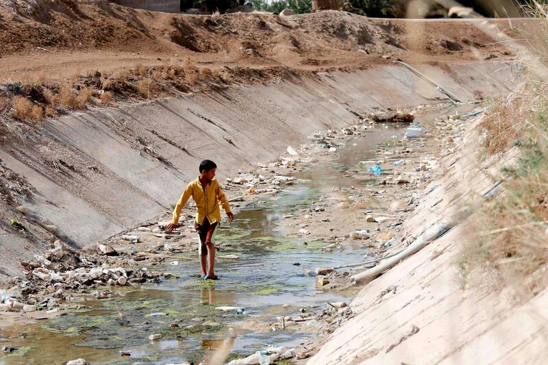 A boy walks along through an almost-empty irrigation channel in the village of Sayyed Dakhil, east of Nasiriyah city, 360 kilometres south of Baghdad.