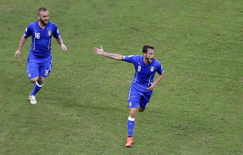 Claudio Marchisio, chased by Daniele De Rossi, celebrates his opening goal against England at the 2014 World Cup on Saturday in Manaus, Brazil. Themba Hadebe / AP