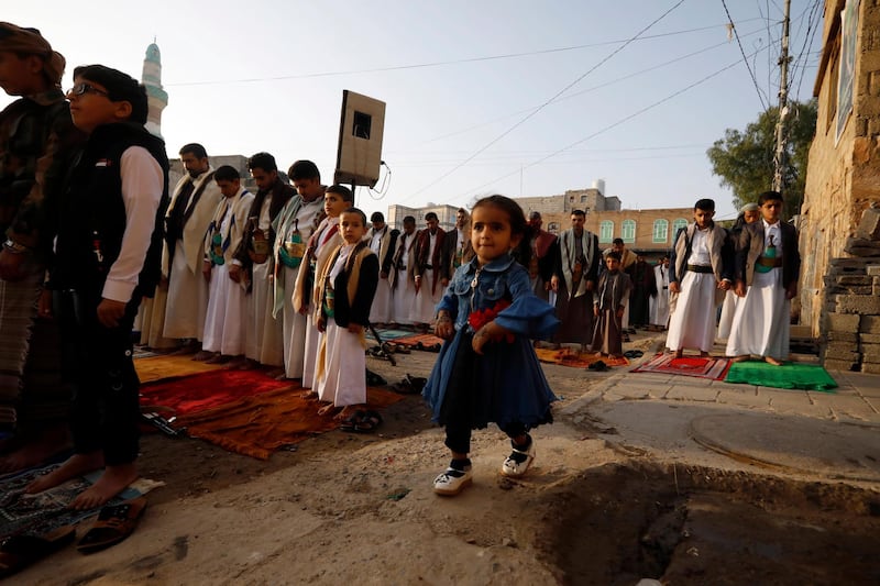 A child passes people at pray for Eid Al Fitr in Sanaa, Yemen. EPA
