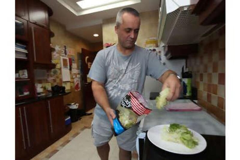 Doug Macaskill prepares his dinner at his home in Abu Dhabi, but he says he would rather put pins in his eyes than cook.