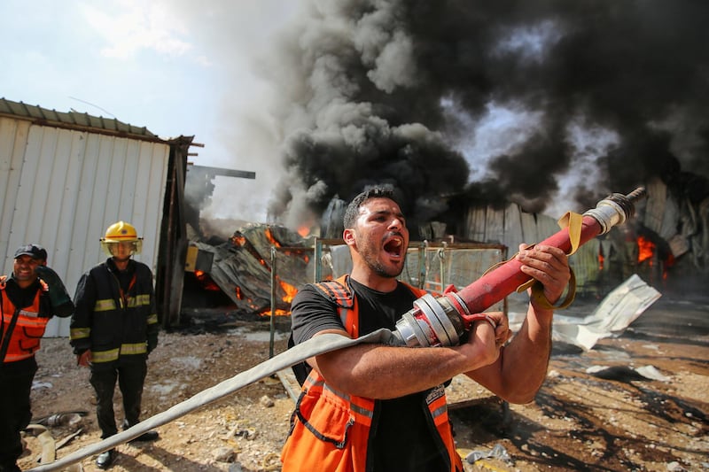 A Palestinian firefighter takes part in efforts to put out a fire at a factory in the northern Gaza Strip after it was hit by Israeli artillery shells. Reuters