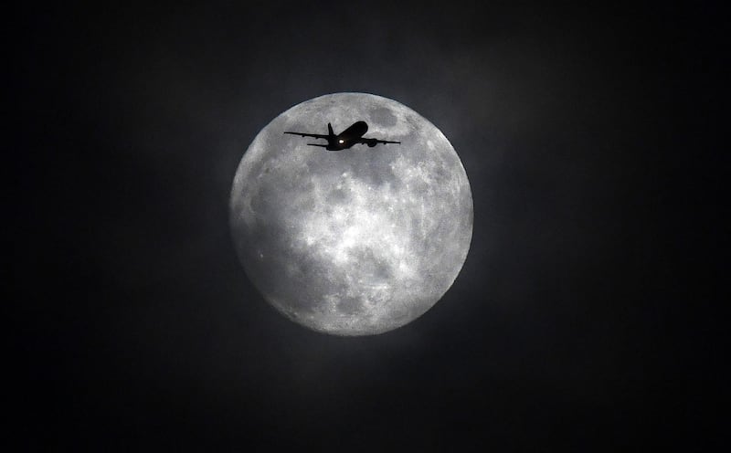 epaselect epa06486356 A plane flies backdropped by the moon in London, Britain, 30 January 2018. On 31 January 2018, a Blue Moon, a total lunar eclipse and a supermoon coincide to create a rare lunar event that hasn't been seen in more than 150 years. This lunar event, called a 'Super Blue Blood Moon' features the second full moon of the month, also known as a Blue Moon, as well as a total lunar eclipse, which is often referred to as a 'blood moon' because the moon turns a reddish color when it passes through Earth's shadow.  EPA/FACUNDO ARRIZABALAGA