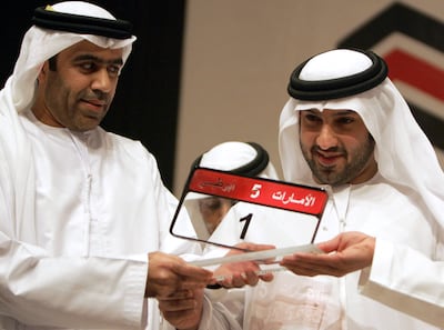 Saeed Khoury (right) poses with the most expensive car number-plate after he won it in an auction in Abu Dhabi on February 16, 2008. AFP