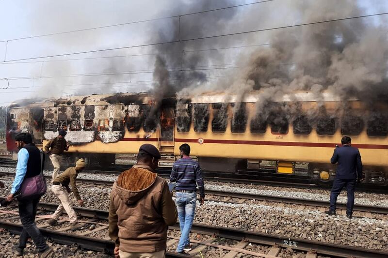 Smoke pours out of a train carriage in the Gaya district of Bihar state after it was set on fire in a protest against alleged irregularities in the recruitment process by Indian Railways. AFP