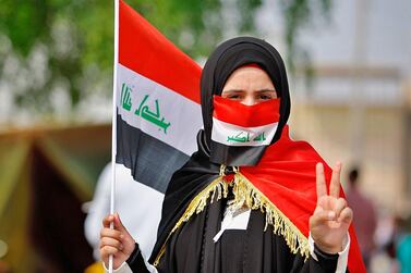 A medical student holds an Iraqi flag while taking part in anti-government protests. AP