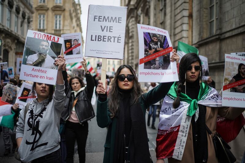 A protester holds a banner reading 'woman life freedom' in Lyon. AP