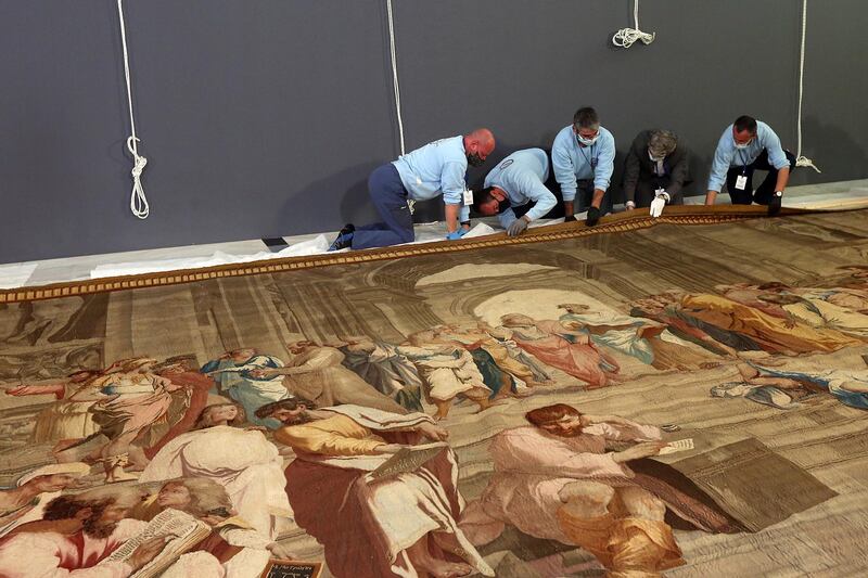 Workers prepare to raise an 18th-century tapestry depicting 'The School of Athens', painted by Renaissance master Raphael, inside the Greek Parliament in Athens, Greece. The tapestry is on loan from France. EPA