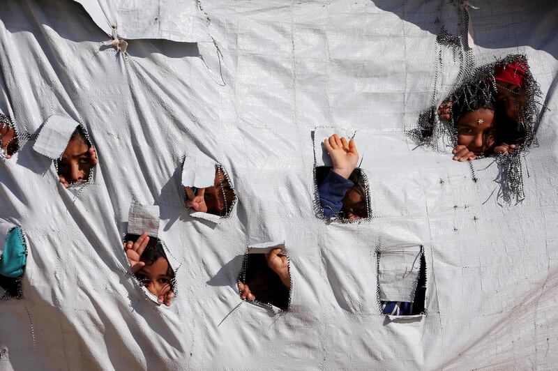 Children look through holes in a tent at al-Hol displacement camp in Hasaka governorate, Syria April 2, 2019. Picture taken April 2, 2019. REUTERS/Ali Hashisho TPX IMAGES OF THE DAY