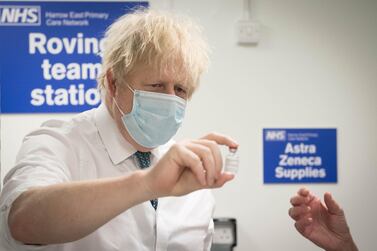 British Prime Minister Boris Johnson examines a vial of the Oxford/AstraZeneca Covid-19 vaccine during a visit to Barnet FC's ground at The Hive in London. WPA