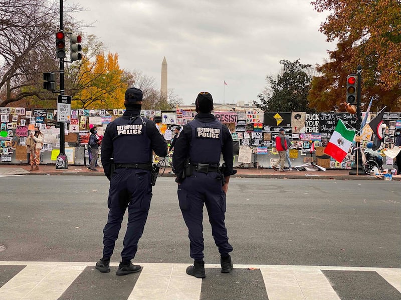 DC police officers stand in front of a fence surrounding Lafayette Square at Black Lives Matter plaza near the White House in Washington, DC.  AFP