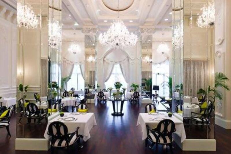 The cream-on-white embossed wall panels, art deco mirrored columns and chandeliers give the restaurant a French formality. Courtesy Vôi / Jumeirah Zabeel Saray