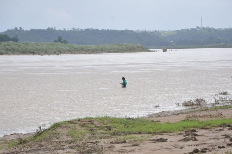 A man fishes in a swollen river caused by heavy rains in Ilagan town, Isabela. AFP