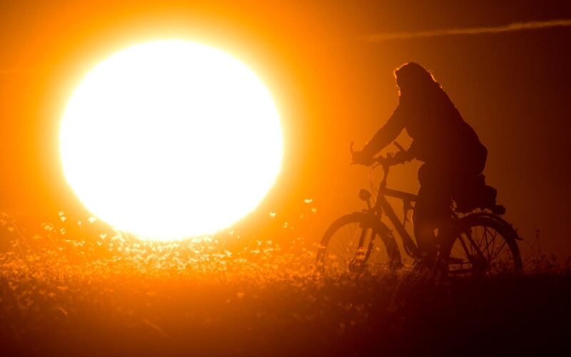 A cyclist silhouetted against the morning sun in Hanover, Germany. AFP