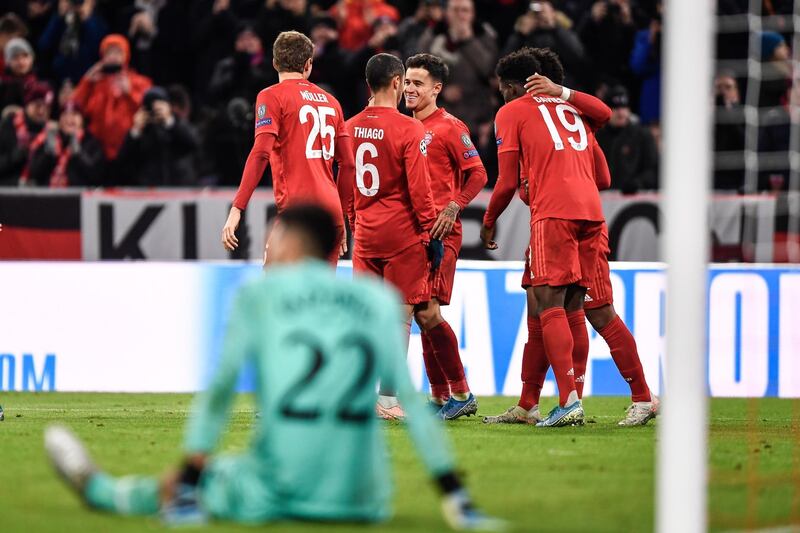 Philippe Coutinho, left, celebrates with teammates after scoring his side's third goal. EPA