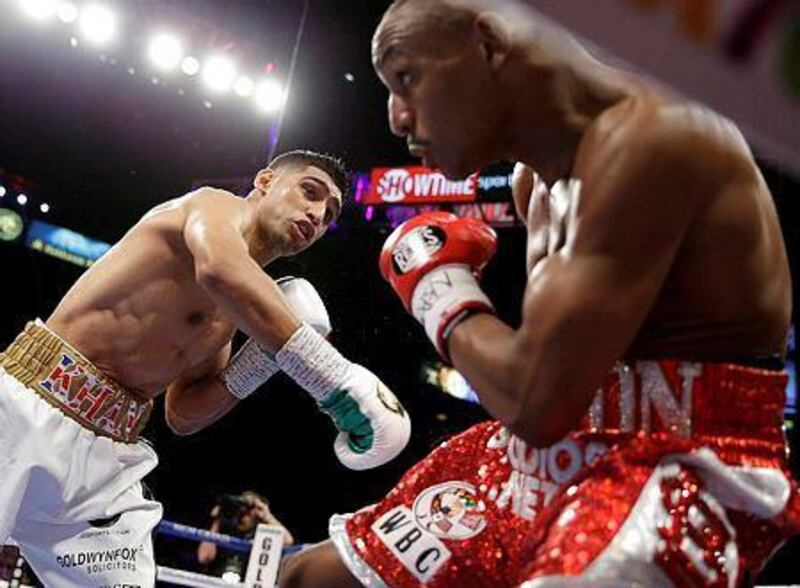 Amir Khan punches Devon Alexander during their welterweight bout Saturday, Dec. 13, 2014, in Las Vegas. (AP Photo/John Locher)