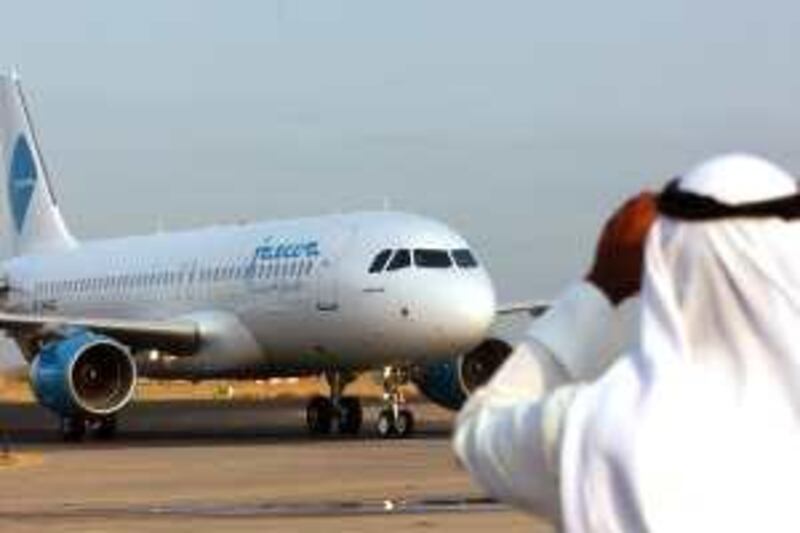 A Kuwaiti man takes photos of the Jazeera Airlines Airbus A-320 plane as it taxies towards the departure gates at Kuwait International Aiport on Sunday Oct. 30, 2005. The Jazeera Airlines private company launched its first flight from Kuwait to Dubai becaming the second airliner to operate in the country besides the state-owned Kuwait Airways Corporation (KAC). (AP Photo/Gustavo Ferrari)