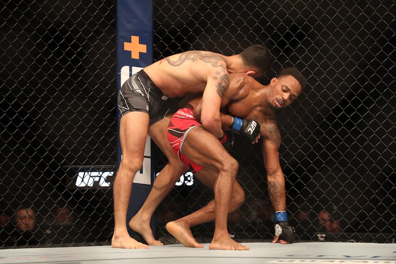 Lerone Murphy (blue) is tackled by Makwan Amirkhani (red) in their featherweight bout.