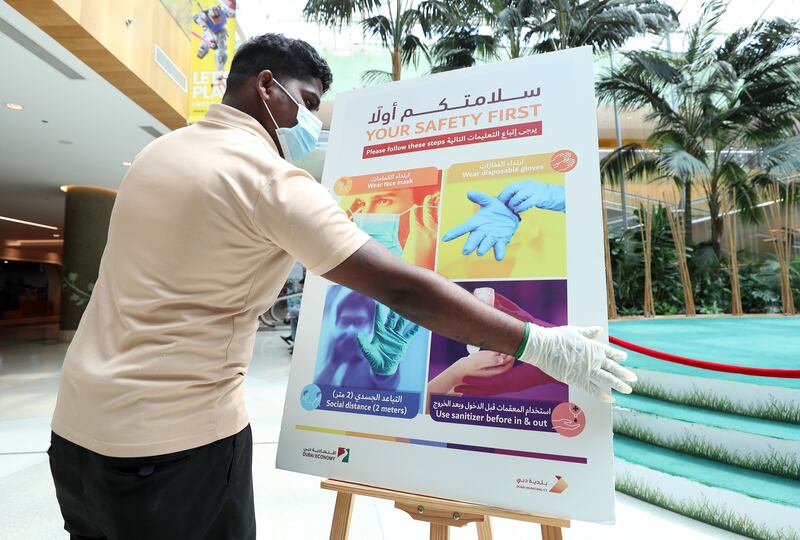 A Covid-19 safety sign is removed from Times Square Centre after face mask rules were removed. Chris Whiteoak / The National