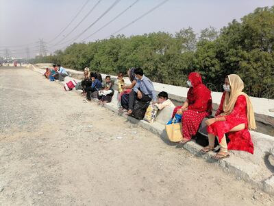 Migrant workers rest on National Highway 24, near Ghaziabad city on the outskirts of New Delhi. Taniya Dutta/ The National