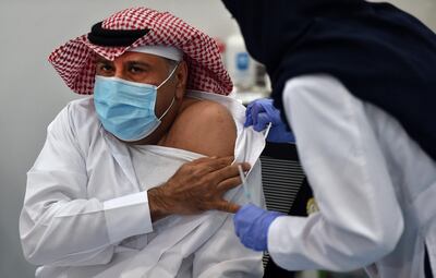 This picture taken on December 17, 2020 shows the first Saudi citizen preparing to receive the Pfizer-BioNTech COVID-19 coronavirus vaccine (Tozinameran) in the capital Riyadh, as part of a vaccination campaign by the Saudi health ministry. (Photo by FAYEZ NURELDINE / AFP)