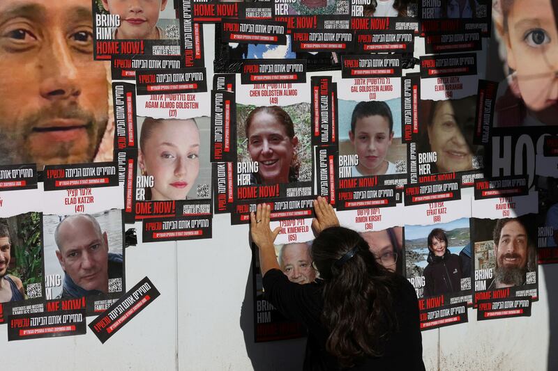 A person in Jerusalem stands next to pictures of the people who were kidnapped by Hamas gunmen on October 7. Reuters