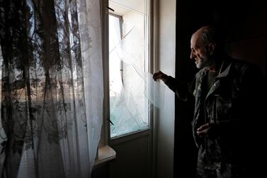 A men removes remains of glass from a window damaged by recent shelling during the military conflict over the breakaway region of Nagorno-Karabakh, in Stepanakert. Reuters