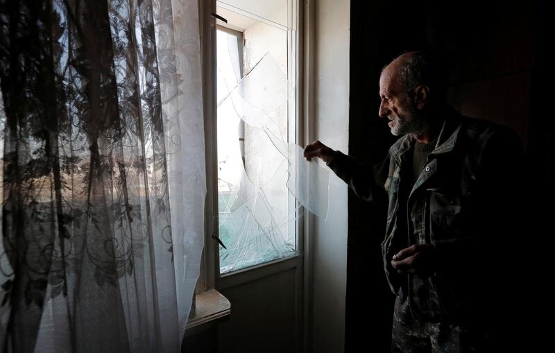 A men removes remains of glass from a window damaged by recent shelling during the military conflict over the breakaway region of Nagorno-Karabakh, in Stepanakert October 13, 2020. REUTERS/Stringer     TPX IMAGES OF THE DAY