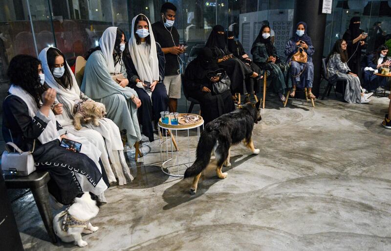 A German shepherd walks past mask-clad patrons sitting with their dogs at the Barking Lot cafe. AFP