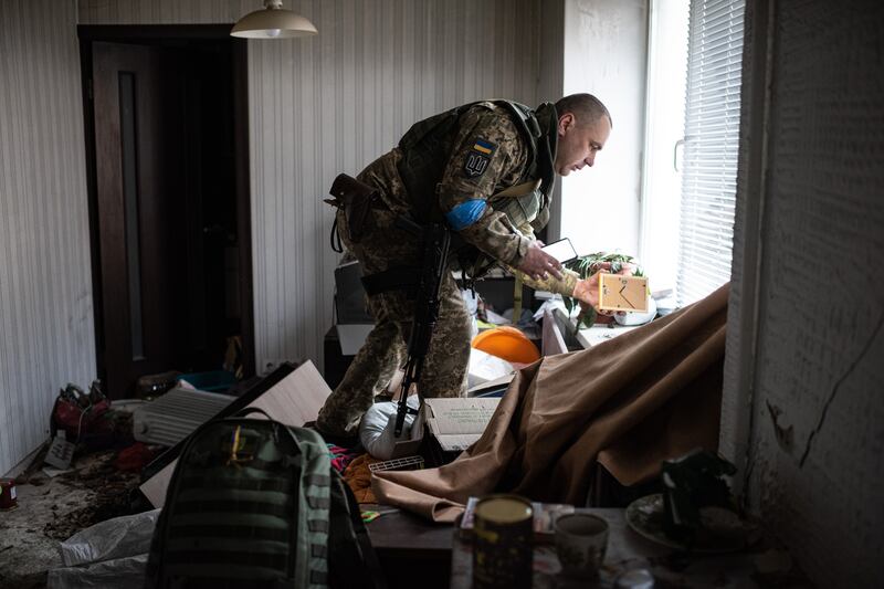 Yurii, 41, who serves in the Ukrainian military, grabs a wedding photograph from his apartment in Hostomel, Ukraine. Getty Images