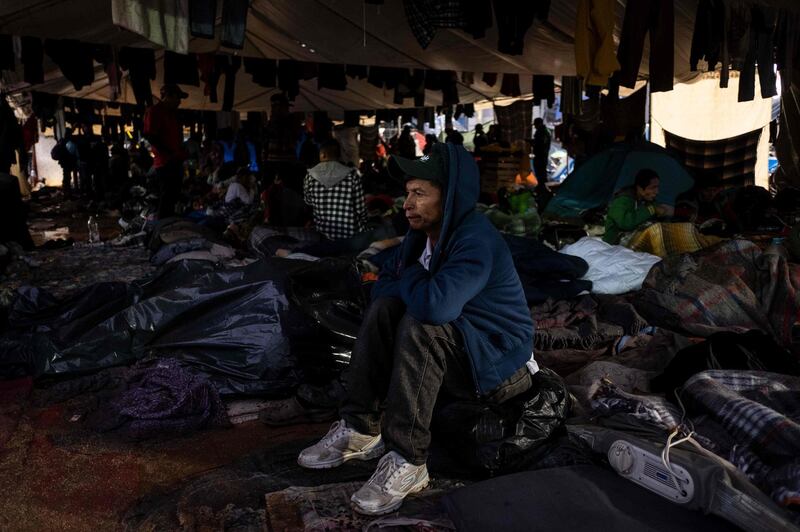 Migrants remain at their temporary shelter after heavy rain. AFP