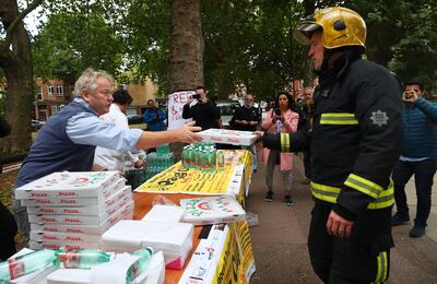 Staff from a local Italian restaurant hands out pizza and water from a stall near Parsons Green tube station in London, Britain September 15, 2017. REUTERS/Hannah McKay