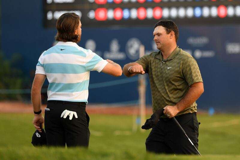 Tommy Fleetwood of England and Patrick Reed of United States interact after finishing their first round of the DP World Tour Championship at Jumeirah Golf Estates. Getty