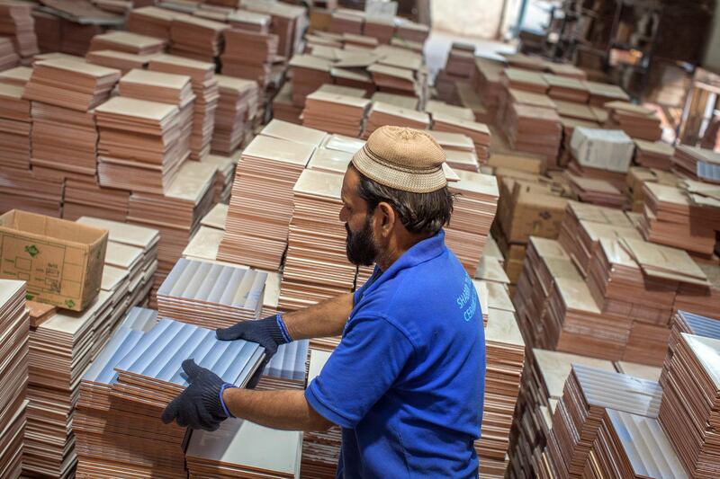 An employee arranges tiles before packing into the boxes at the Shabbir Tiles & Ceramics Ltd. production facility in Karachi, Pakistan, on Wednesday, Dec. 6, 2017. Shabbir, which had suffered four years of losses while fighting to compete with cheap imports from neighboring China, is on course to post an annual profit next financial year after Pakistan placed an anti-dumping duty on Chinese tiles in October. That follows similar moves from the regulator on steel products. Photographer: Asim Hafeez/Bloomberg