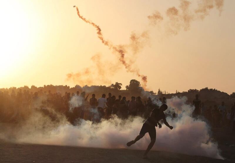 A Palestinian protester throws a tear gas canister fired by Israeli troops during clashes near the border in Gaza on October 16, 2015. Ibraheem Abu Mustafa/Reuters