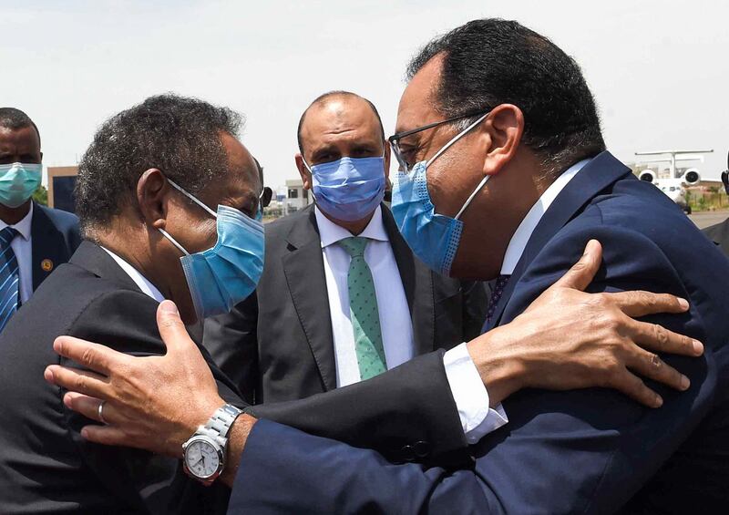 A handout picture released by the Egyptian Prime Minister's official Facebook page on August 15, 2020 shows the mask-clad (COVID-19 coronavirus pandemic precaution) PM Mostafa Madbouli (R) being embraced by Sudan's PM Abdalla Hamdok (L) at the capital's Khartoum International Airport. === RESTRICTED TO EDITORIAL USE - MANDATORY CREDIT "AFP PHOTO / HO / EGYPTIAN PRIME MINISTER'S OFFICE"- NO MARKETING NO ADVERTISING CAMPAIGNS - DISTRIBUTED AS A SERVICE TO CLIENTS ==

 / AFP / Egyptian Prime Minister's Office / - / === RESTRICTED TO EDITORIAL USE - MANDATORY CREDIT "AFP PHOTO / HO / EGYPTIAN PRIME MINISTER'S OFFICE"- NO MARKETING NO ADVERTISING CAMPAIGNS - DISTRIBUTED AS A SERVICE TO CLIENTS ==


