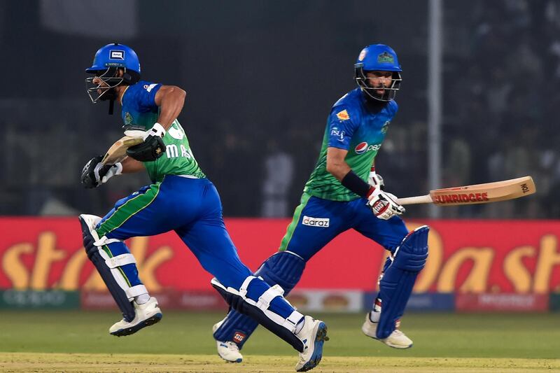 Multan Sultans's Moeen Ali (R) and Shan Masood run between the wicket during the Pakistan Super League (PSL) Twenty20 cricket match between Multan Sultans and Peshawar Zalmi at the Multan Cricket Stadium in Multan on February 26, 2020. (Photo by Arif ALI / AFP)