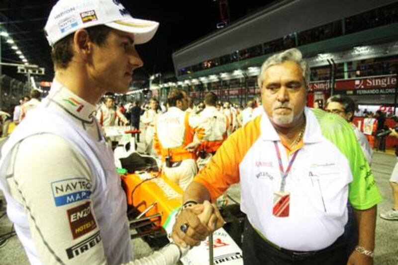Dr Vijay Mallya, right, congratulating one of his drivers, Adrian Sutil, after the Singapore GP, is refuting reports that he is interested in selling the Force India team.