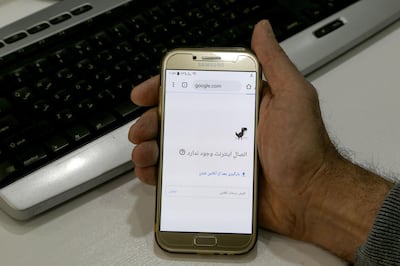 A man holds a smartphone connected to a Wifi network without internet access at an office in the Iranian capital Tehran on November 17, 2019. Iran's supreme leader on November 17 threw his support behind a decision to hike petrol prices, a move that sparked nationwide unrest in which he said "some lost their lives". Access to the internet has been restricted since demonstrations broke out two days prior, after a decision by the Supreme National Security Council of Iran, according to a report by semi-official news agency ISNA. / AFP / ATTA KENARE

