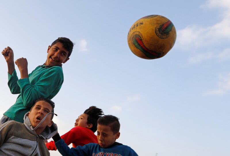 Children play football on a dusty field in Cairo, Egypt. Reuters