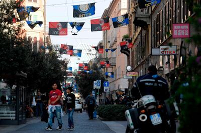Flags of Italian football clubs Inter Milan and AC Milan are hanged in the Paolo Sarpi street, a chinese neighborhood of Milan, on October 13, 2017. Milan's derby on October 15, 2017 takes on even more significance as both teams are now under Chinese ownership -- Inter on the payroll of the Suning Group and Milan, the Rossoneri Sport Investment Lux Group. / AFP PHOTO / MIGUEL MEDINA