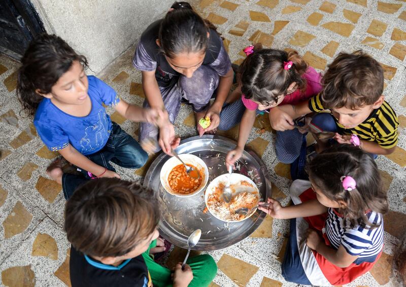 The grandchildren of 61-year-old Iraqi matriarch Sana Ibrahim share a meal in their family home in the northern city of Mosul. AFP