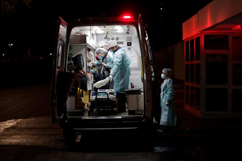 Healthcare workers of the public Mobile Emergency Service prepare their ambulance to transport a patient suspected of suffering from Covid-19 in Brasilia, Brazil. AP Photo