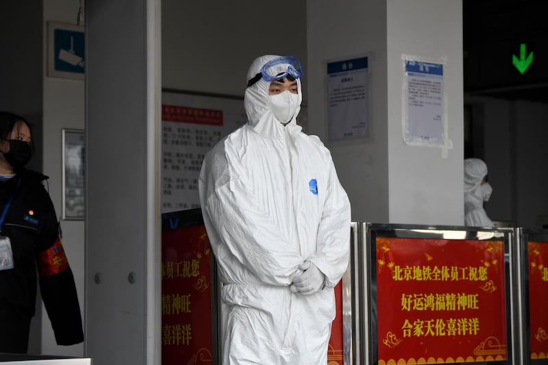 A security person wearing protective clothing to help stop the spread of a deadly SARS-like virus which originated in the central city of Wuhan is seenseen at the entrance of subway station in Beijing.  AFP